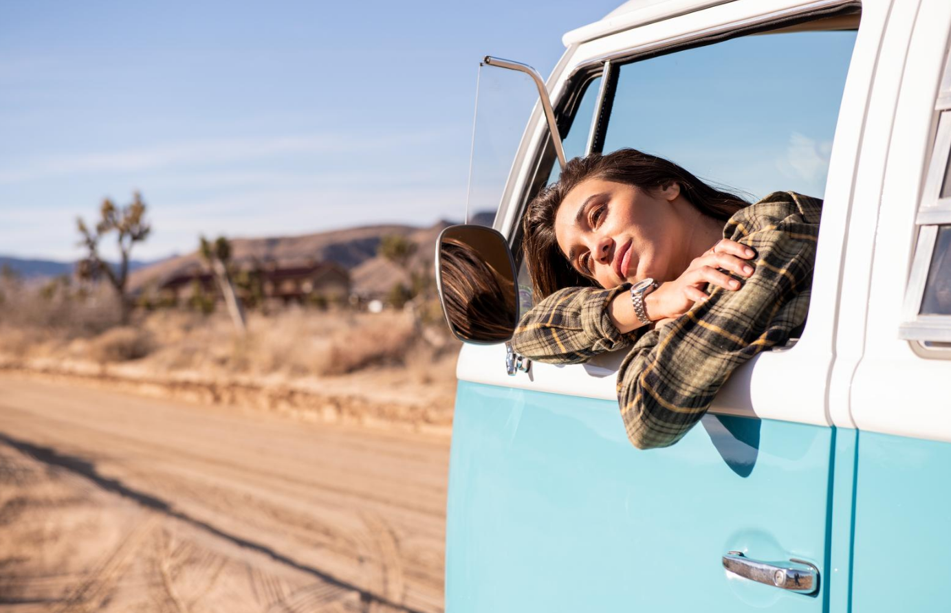 Girl hanging outside driver side window of a van with a Nixon Optimist watch